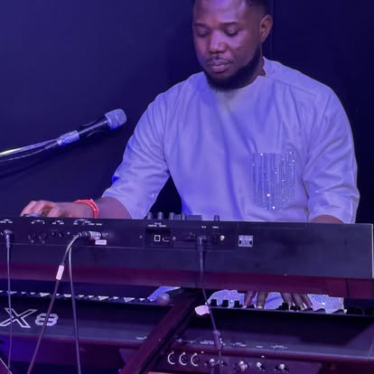 Joel Elijah Okhase playing keyboard during a live performance